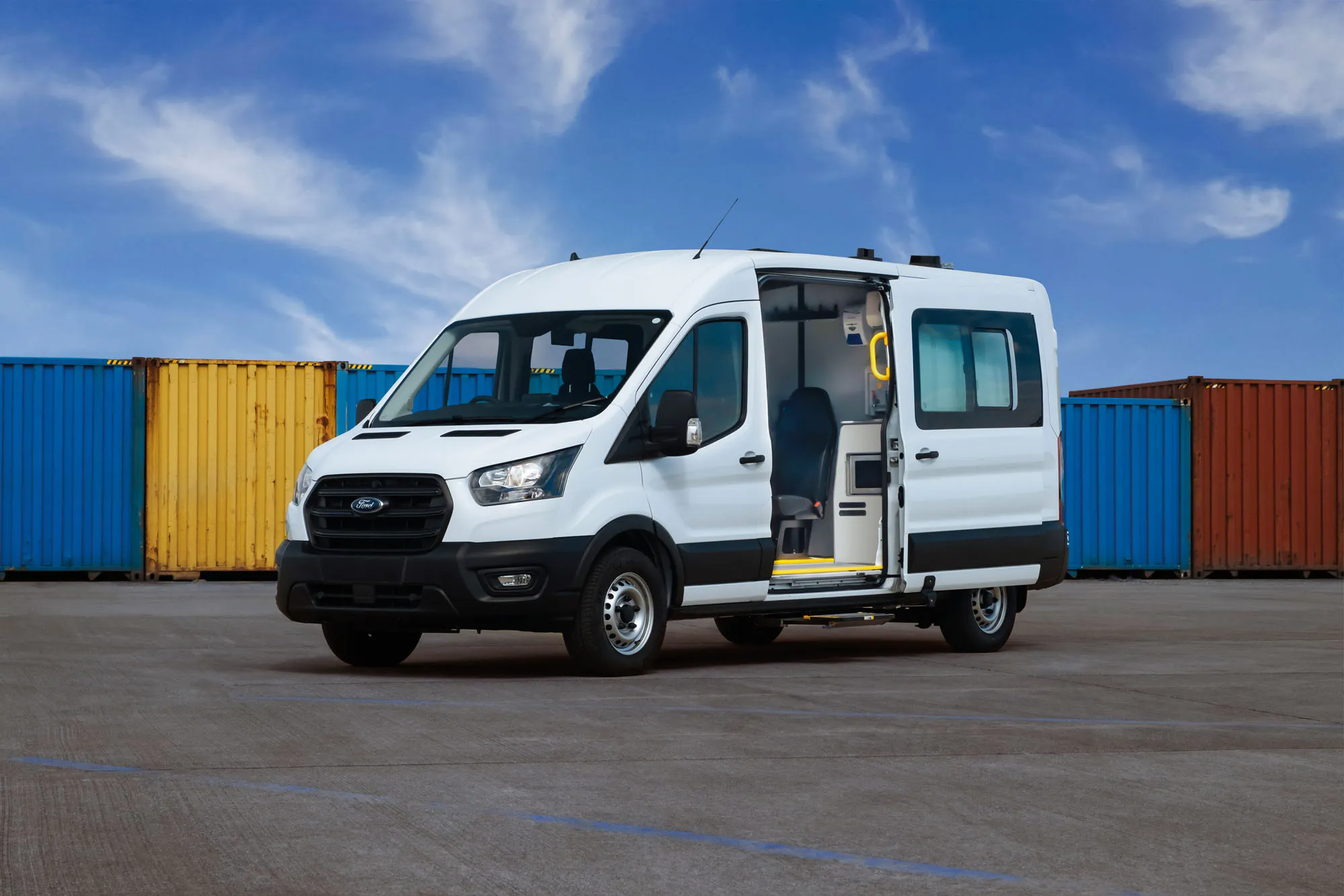 white van in car park infront of coloured shipping containers