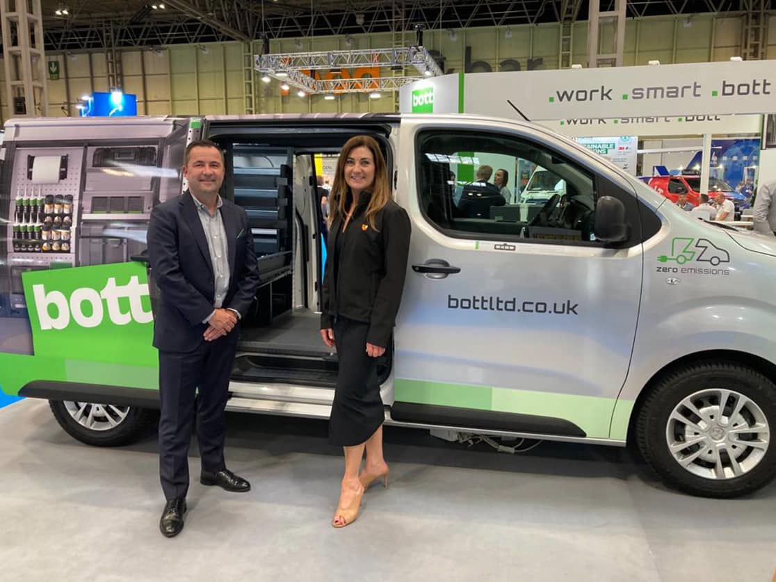 man and woman stood next to van with custom van racking inside & bott van wrapping on exterior - at trade fair