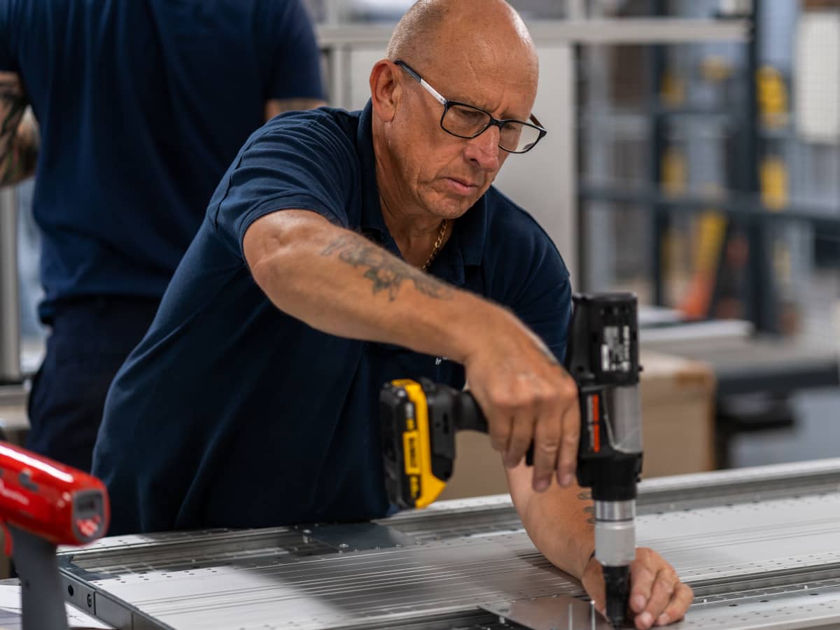man uses screwdriver to manufacture custom van racking module - modular van racking - bott ltd