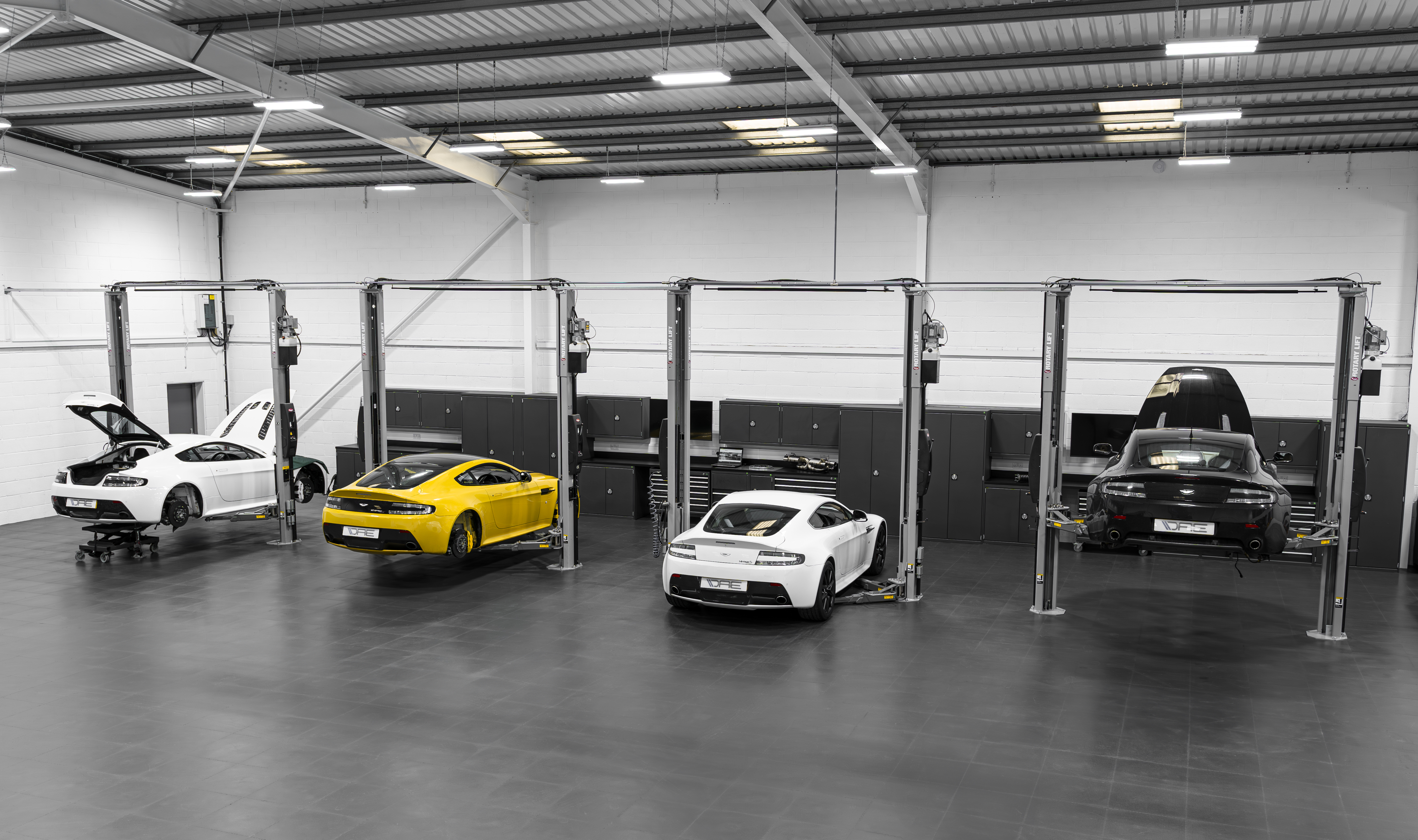 four vans lined up in warehouse for inspection